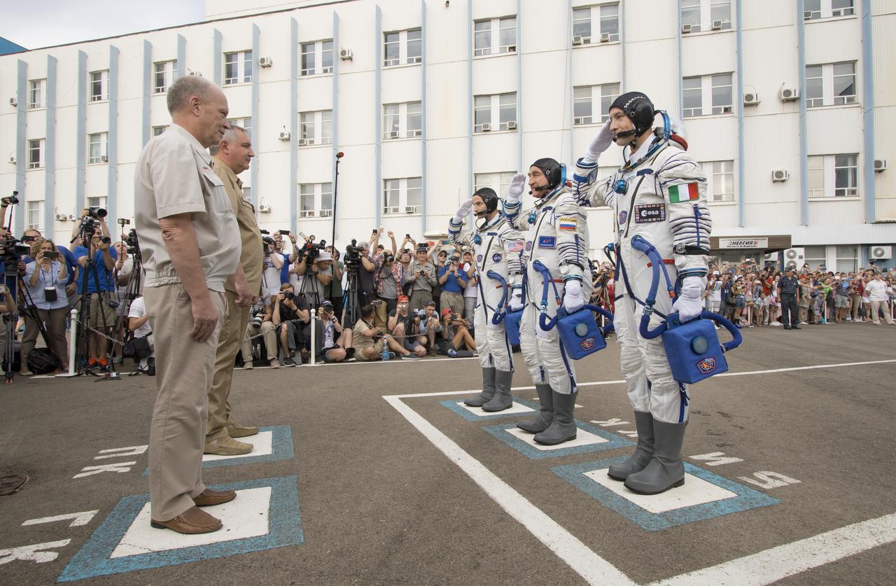 Expedition 60 flight engineer Andrew Morgan of NASA, left, Soyuz Commander Alexander Skvortsov of Roscosmos, center, and flight engineer Luca Parmitano of ESA (European Space Agency), right, report to mission managers prior to departing Building 254 for the launch pad after donning their Russian Sokol suits, Saturday, July 20, 2019 at the Baikonur Cosmodrome in Kazakhstan. Morgan, Skvortsov, and Parmitano launched aboard the Soyuz MS-13 spacecraft at 12:28 p.m. Eastern time (9:28 p.m. Baikonur time) on July 20 to begin their journey to the International Space Station. Photo Credit: (NASA/Victor Zelentsov)