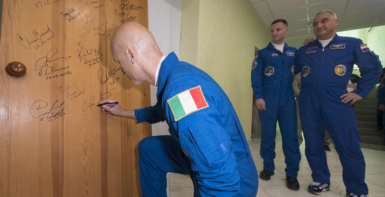 Expedition 60 flight engineer Luca Parmitano of ESA (European Space Agency) performs the traditional door signing at the Cosmonaut Hotel prior to departing the hotel for launch on a Soyuz rocket with fellow crewmates Andrew Morgan of NASA and Alexander Skvortsov of Roscosmos, Saturday, July 20, 2019 in Baikonur, Kazakhstan. Skvortsov, Morgan, and Parmitano launched at 12:28 p.m. Eastern time (9:28 p.m. Baikonur time) to begin their mission to the International Space Station. Photo Credit: (NASA/Joel Kowsky)