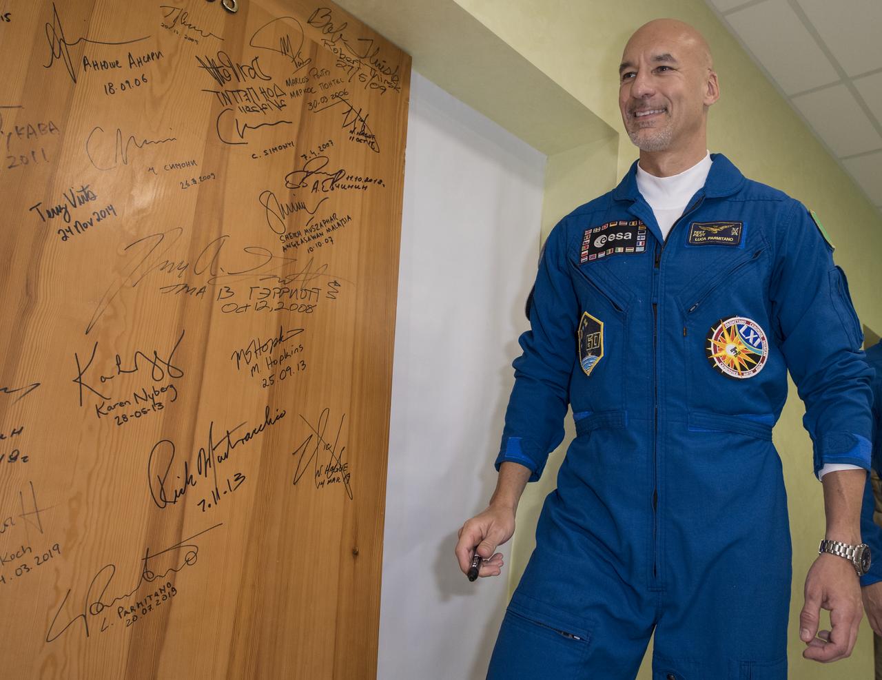Expedition 60 flight engineer Luca Parmitano of ESA (European Space Agency) performs the traditional door signing at the Cosmonaut Hotel prior to departing the hotel for launch on a Soyuz rocket with fellow crewmates Andrew Morgan of NASA and Alexander Skvortsov of Roscosmos, Saturday, July 20, 2019 in Baikonur, Kazakhstan. Skvortsov, Morgan, and Parmitano launched at 12:28 p.m. Eastern time (9:28 p.m. Baikonur time) to begin their mission to the International Space Station. Photo Credit: (NASA/Joel Kowsky)