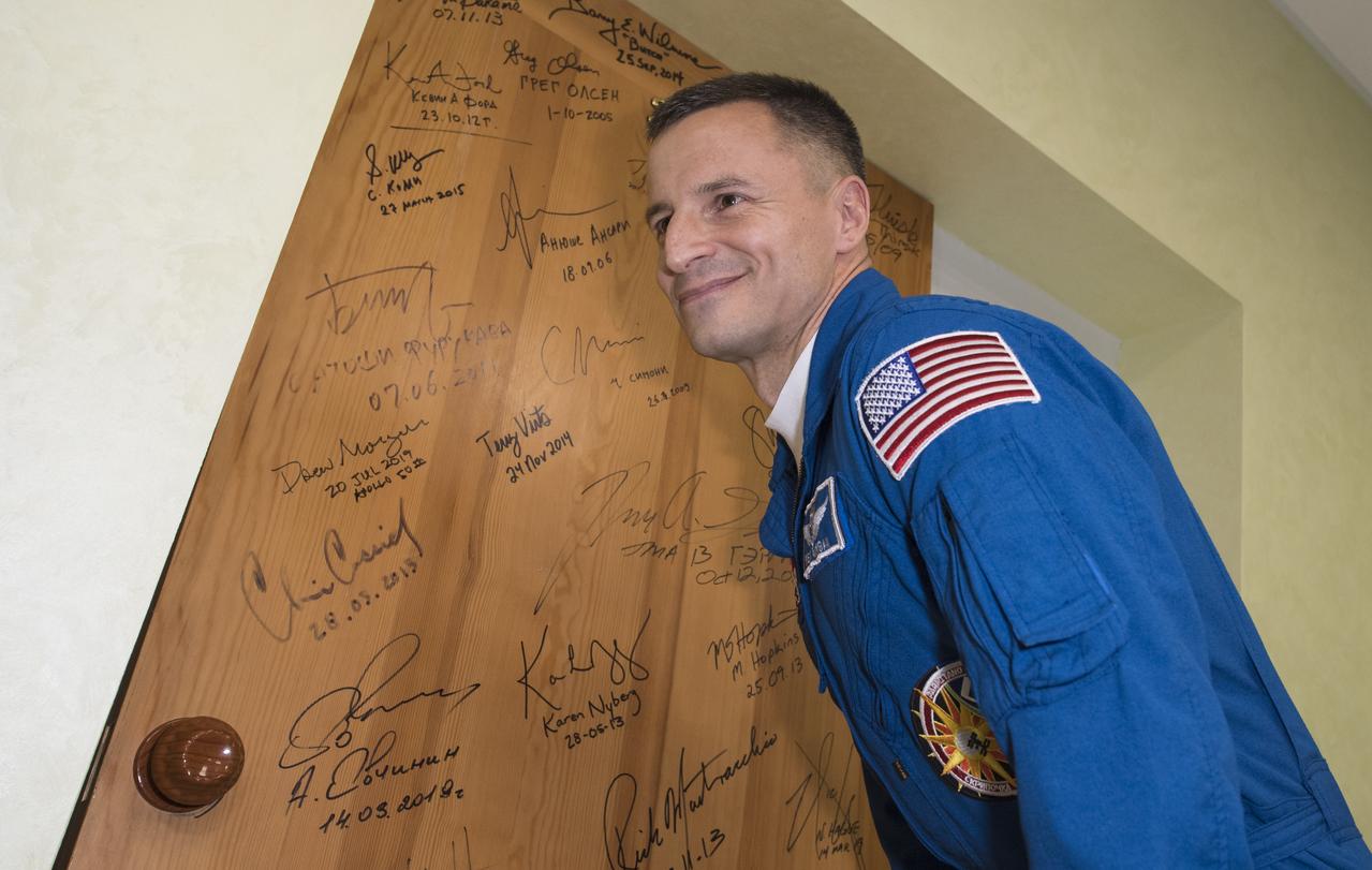 Expedition 60 flight engineer Andrew Morgan of NASA performs the traditional door signing at the Cosmonaut Hotel prior to departing the hotel for launch on a Soyuz rocket with fellow crewmates Alexander Skvortsov of Roscosmos and Luca Parmitano of ESA (European Space Agency), Saturday, July 20, 2019 in Baikonur, Kazakhstan. Skvortsov, Morgan, and Parmitano launched at 12:28 p.m. Eastern time (9:28 p.m. Baikonur time) to begin their mission to the International Space Station.  Photo Credit: (NASA/Joel Kowsky)