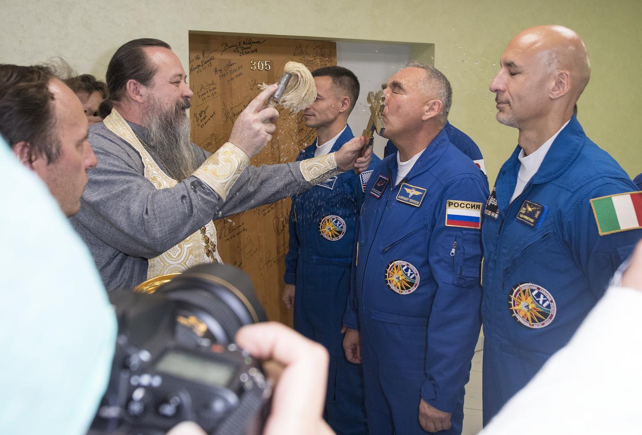 Expedition 60 Soyuz Commander Alexander Skvortsov of Roscosmos is blessed by a Russian Orthodox Priest in the Cosmonaut Hotel prior to departing for launch on a Soyuz rocket with fellow crewmates Andrew Morgan of NASA and Luca Parmitano of ESA (European Space Agency), Saturday, July 20, 2019 in Baikonur, Kazakhstan. Skvortsov, Morgan, and Parmitano launched at 12:28 p.m. Eastern time (9:28 p.m. Baikonur time) to begin their mission to the International Space Station. Photo Credit: (NASA/Joel Kowsky)