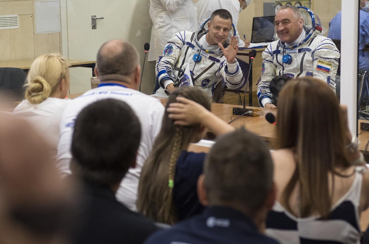 Expedition 60 flight engineer Andrew Morgan of NASA, left, and Soyuz Commander Alexander Skvortsov of Roscosmos, right, speak with family and friends after having their Russian Sokol suits pressure checked in preparation for launch aboard the Soyuz MS-13 spacecraft, Saturday, July 20, 2019 at the Baikonur Cosmodrome in Kazakhstan. Morgan, Skvortsov, and Luca Parmitano of ESA (European Space Agency) launched aboard the Soyuz MS-13 spacecraft at 12:28 p.m. Eastern time (9:28 p.m. Baikonur time) on July 20 to begin their journey to the International Space Station. Photo Credit: (NASA/Joel Kowsky)