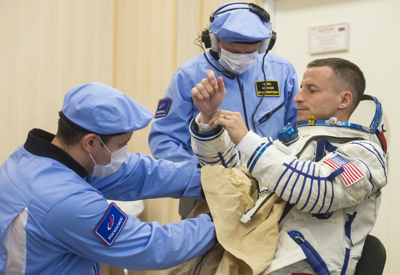 Expedition 60 flight engineer Andrew Morgan of NASA is helped into his Russian Sokol suit as he and fellow cremates Alexander Skvortsov of Roscosmos and Luca Parmitano of ESA (European Space Agency) prepare for their Soyuz launch to the International Space Station Saturday, July 20, 2019 in Baikonur, Kazakhstan.  Morgan, Alexander Skvortsov of Roscosmos, and Luca Parmitano of ESA (European Space Agency) launched aboard the Soyuz MS-13 spacecraft at 12:28 p.m. Eastern time (9:28 p.m. Baikonur time) on July 20 to begin their journey to the orbiting laboratory. Photo Credit: (NASA/GCTC/Andrey Shelepin)