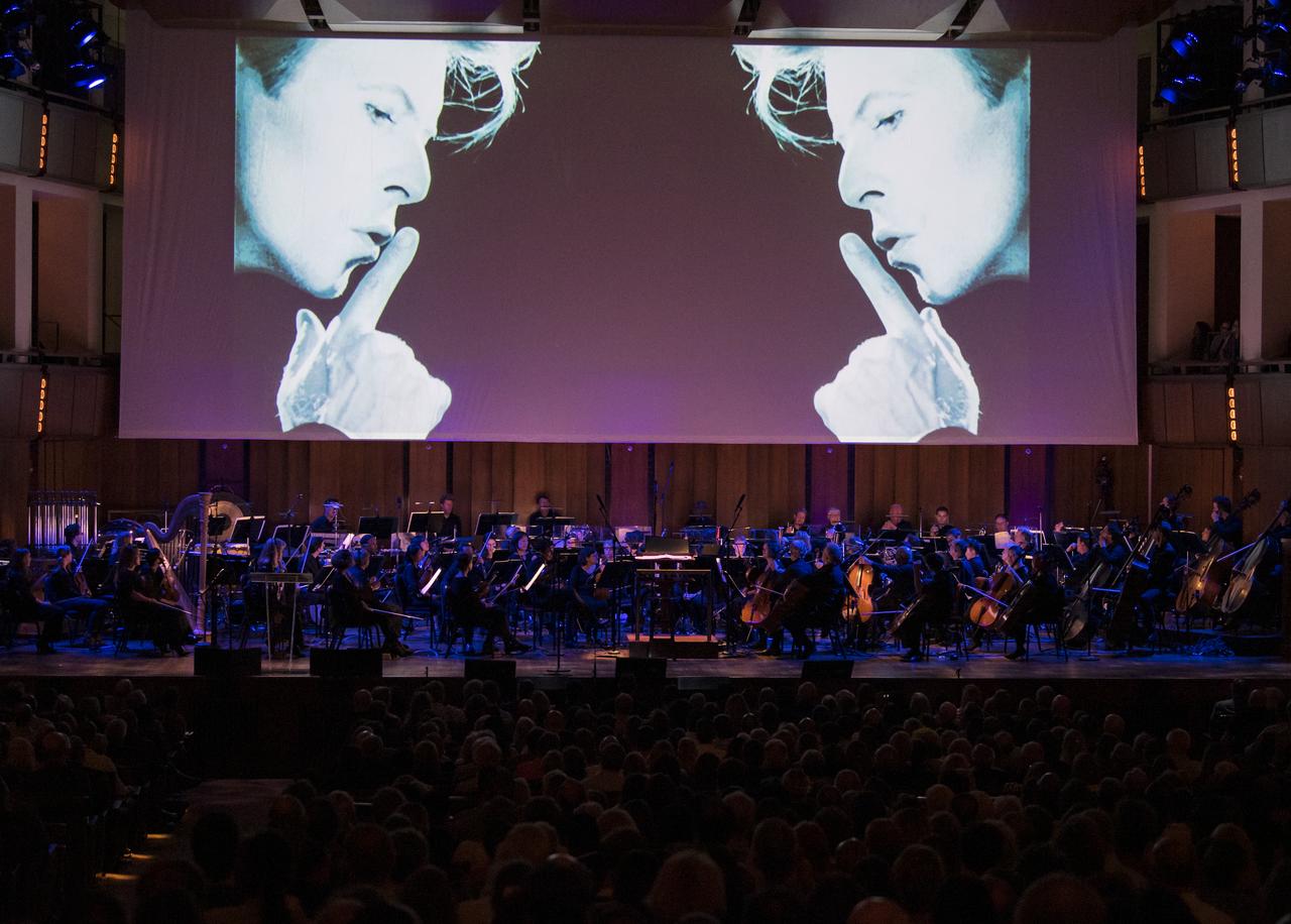 A new music video for David Bowie's "Space Oddity" is premiered during the "National Symphony Orchestra Pops, Apollo 11: A 50th Anniversary, One Small Step, One Giant Leap" a program including musical acts, speakers, and images and video related to space, on Saturday, July 20, 2019 at the John F. Kennedy Center for the Performing Arts in Washington. NASA and the country are recognizing the 50th anniversary of Apollo 11, in which astronauts Neil Armstrong, Michael Collins, and Buzz Aldrin crewed the first mission to land astronauts on the Moon. Photo Credit: (NASA/Aubrey Gemignani)