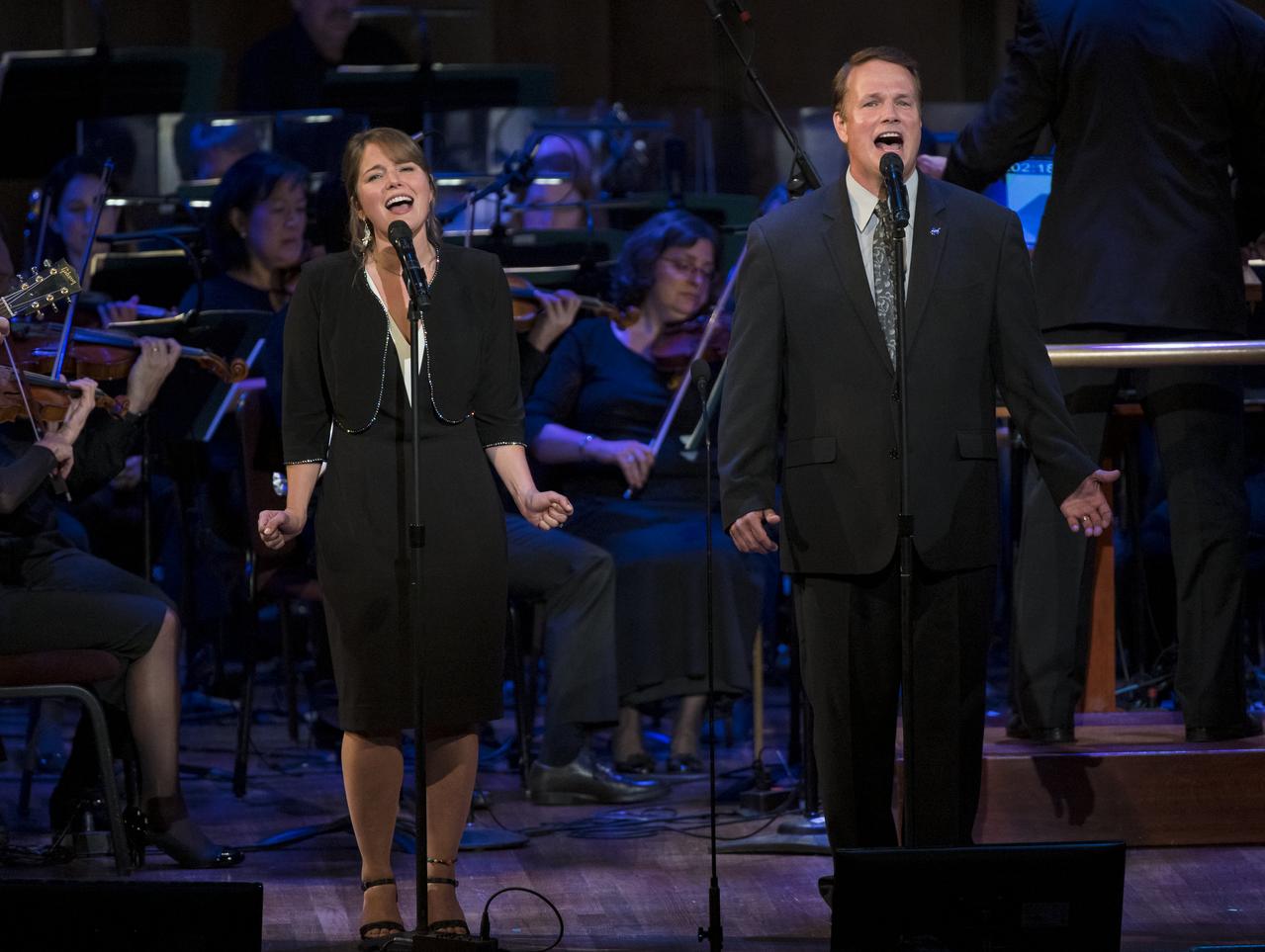 Son of Apollo 11 astronaut Neil Armstrong, Mark Armstrong, right, and his daughter, sing a song he wrote about his father, "Flight of Fancy," during the "National Symphony Orchestra Pops, Apollo 11: A 50th Anniversary, One Small Step, One Giant Leap" a program including musical acts, speakers, and images and video related to space, on Saturday, July 20, 2019 at the John F. Kennedy Center for the Performing Arts in Washington. NASA and the country are recognizing the 50th anniversary of Apollo 11, in which astronauts Neil Armstrong, Michael Collins, and Buzz Aldrin crewed the first mission to land astronauts on the Moon. Photo Credit: (NASA/Aubrey Gemignani)