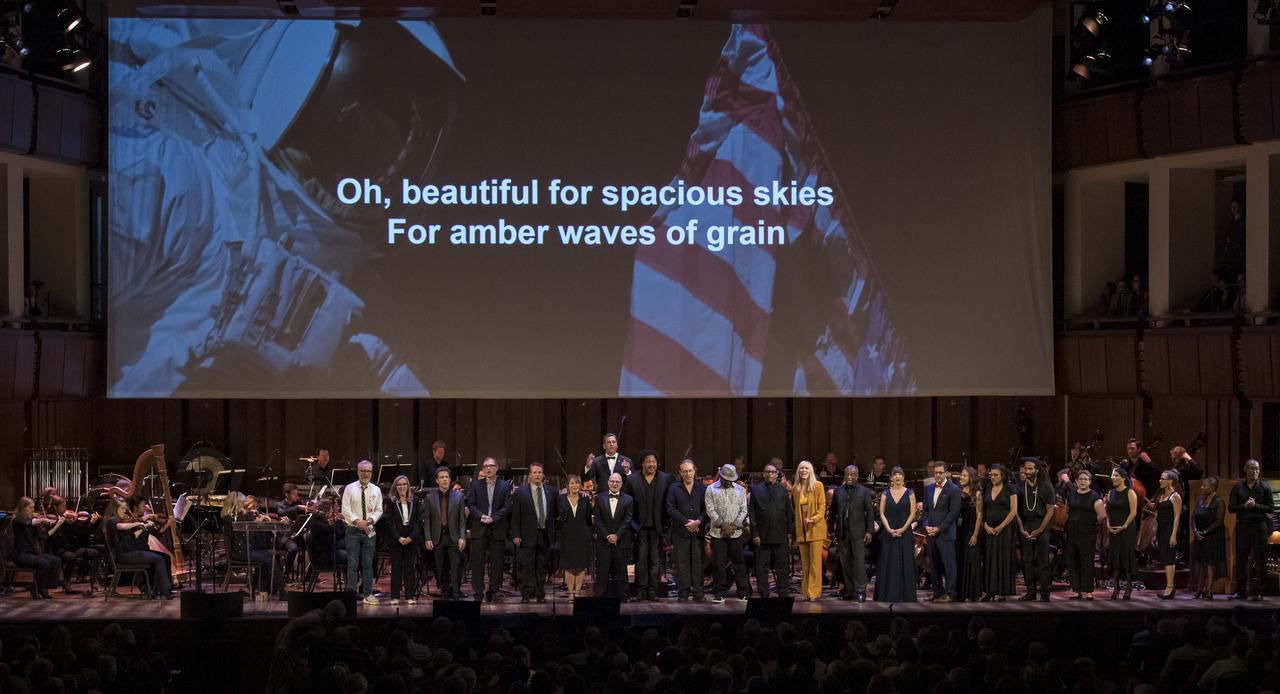 All members of the program sing "America, the Beautiful" at the conclusion of the "National Symphony Orchestra Pops, Apollo 11: A 50th Anniversary, One Small Step, One Giant Leap" which included musical acts, speakers, and images and video related to space, on Saturday, July 20, 2019 at the John F. Kennedy Center for the Performing Arts in Washington. NASA and the country are recognizing the 50th anniversary of Apollo 11, in which astronauts Neil Armstrong, Michael Collins, and Buzz Aldrin crewed the first mission to land astronauts on the Moon. Photo Credit: (NASA/Aubrey Gemignani)