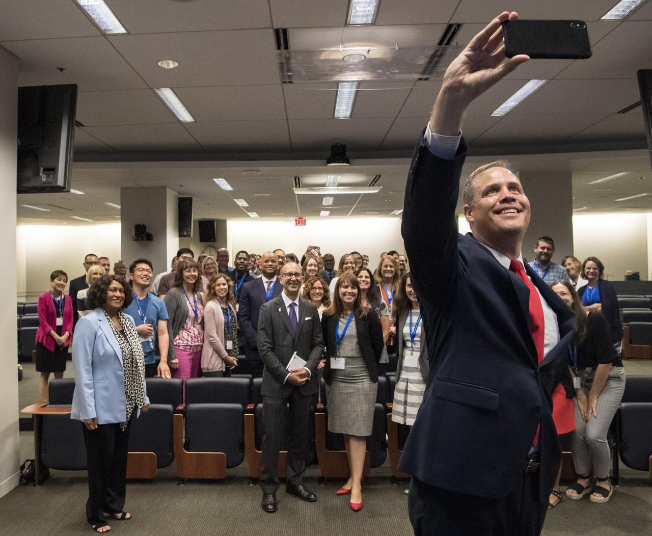 NASA Administrator Jim Bridenstine takes a selfie with the audience at the Challenger Center Annual Conference, Wednesday, August 14, 2019 at the Lockheed Martin Global Vision Center in Arlington, VA. Photo Credit: (NASA/Aubrey Gemignani)