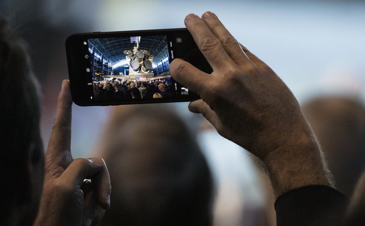 A member of the audience takes a picture with their phone as Vice President Mike Pence is introduced during the sixth meeting of the National Space Council, Tuesday, Aug. 20, 2019 at the Smithsonian National Air and Space Museum's Steven F. Udvar-Hazy Center in Chantilly, Va. Chaired by the Vice President, the council's role is to advise the President regarding national space policy and strategy, and review the nation's long-range goals for space activities. Photo Credit: (NASA/Joel Kowsky)