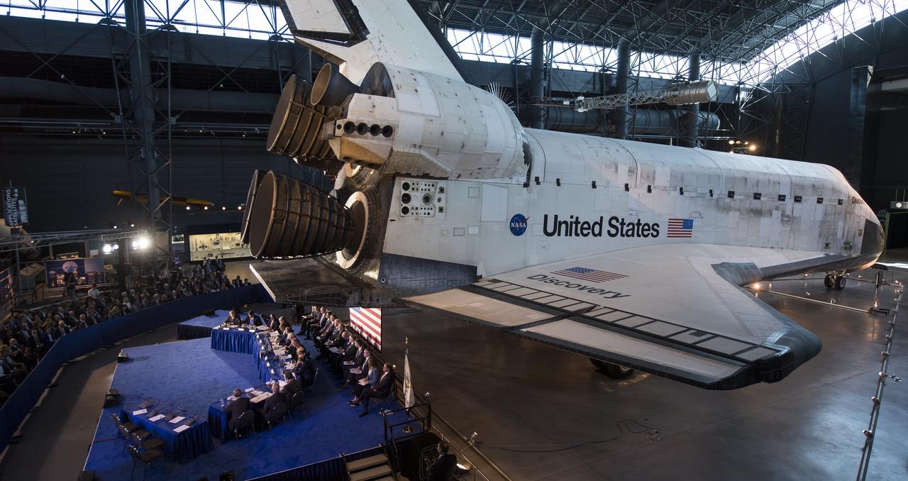 Members of the National Space Council are seen under space shuttle Discovery during the council's sixth meeting, Tuesday, Aug. 20, 2019 at the Smithsonian National Air and Space Museum's Steven F. Udvar-Hazy Center in Chantilly, Va. Chaired by Vice President Mike Pence, the council's role is to advise the President regarding national space policy and strategy, and review the nation's long-range goals for space activities. Photo Credit: (NASA/Aubrey Gemignani)