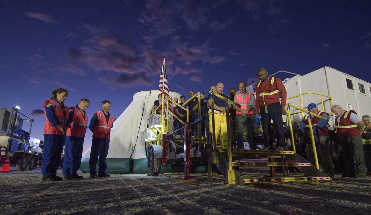 NASA astronauts Nicole Mann and Mike Fincke and Boeing astronaut Chris Ferguson observe a moment of silence with teams from NASA, Boeing and the White Sands Missile Range, honoring the victims of the Sept. 11 terrorist attacks, Wednesday, Sept. 11, 2019 at the White Sands Missile Range outside Las Cruces, New Mexico. The joint teams gathered in the desert to rehearse landing and crew extrication from Boeing’s CST-100 Starliner, which will be used to carry humans to the International Space Station. Mann, Fincke and Ferguson will fly to the space station aboard the Starliner for the Boeing Crew Flight Test mission. Photo Credit: (NASA/Bill Ingalls)