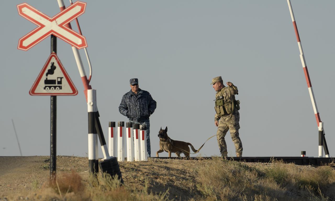 A K-9 advance team patrols the railroad tracks as the Soyuz rocket is rolled out by train to the launch pad, Monday, Sept. 23, 2019 at the Baikonur Cosmodrome in Kazakhstan. Expedition 61 crewmembers Jessica Meir of NASA and Oleg Skripochka of Roscosmos, and spaceflight participant Hazzaa Ali Almansoori of the United Arab Emirates will launch September 25th on the Soyuz MS-15 spacecraft from the Baikonur Cosmodrome to the International Space Station. Photo Credit: (NASA/Bill Ingalls)