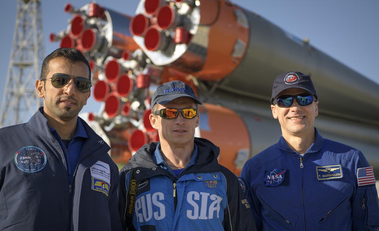Backup spaceflight participant Sultan Al-Neyadi of the United Arab Emirates, left, and Expedition 61 backup crewmembers Sergei Ryzhikov of Roscosmos and Thomas Marshburn of NASA, pose for a photograph as the Soyuz rocket is rolled out by train to the launch pad, Monday, Sept. 23, 2019 at the Baikonur Cosmodrome in Kazakhstan. Expedition 61 crewmembers Jessica Meir of NASA and Oleg Skripochka of Roscosmos, and spaceflight participant Hazzaa Ali Almansoori of the United Arab Emirates will launch September 25th on the Soyuz MS-15 spacecraft from the Baikonur Cosmodrome to the International Space Station. Photo Credit: (NASA/Bill Ingalls)