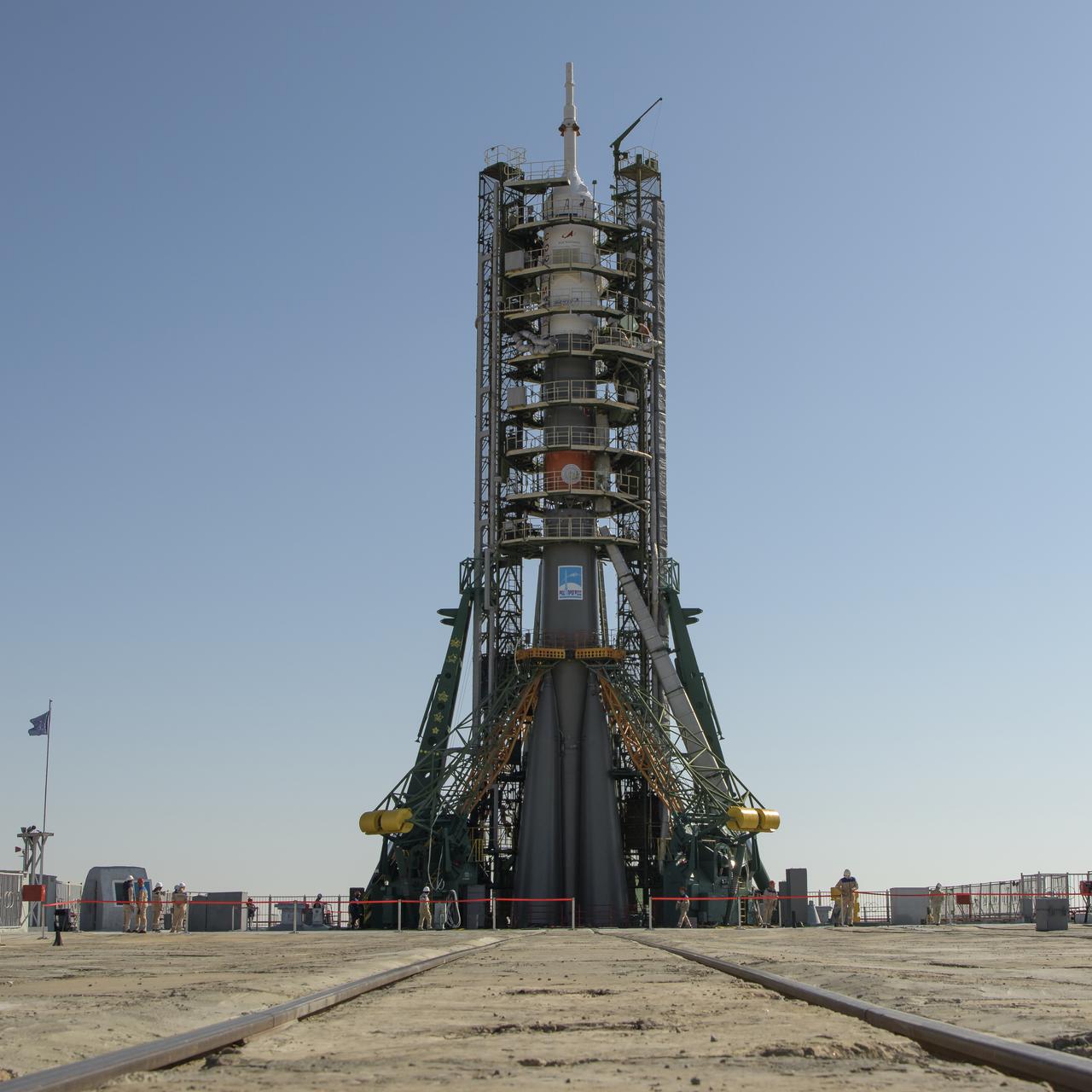 The gantry arms close around the Soyuz rocket after it was raised into vertical position on the launch pad, Monday, Sept. 23, 2019 at the Baikonur Cosmodrome in Kazakhstan. Expedition 61 crewmembers Jessica Meir of NASA, Oleg Skripochka of Roscosmos, and spaceflight participant Hazzaa Ali Almansoori of the United Arab Emirates will launch September 25th on the Soyuz MS-15 spacecraft from the Baikonur Cosmodrome to the International Space Station. Photo Credit: (NASA/Bill Ingalls)