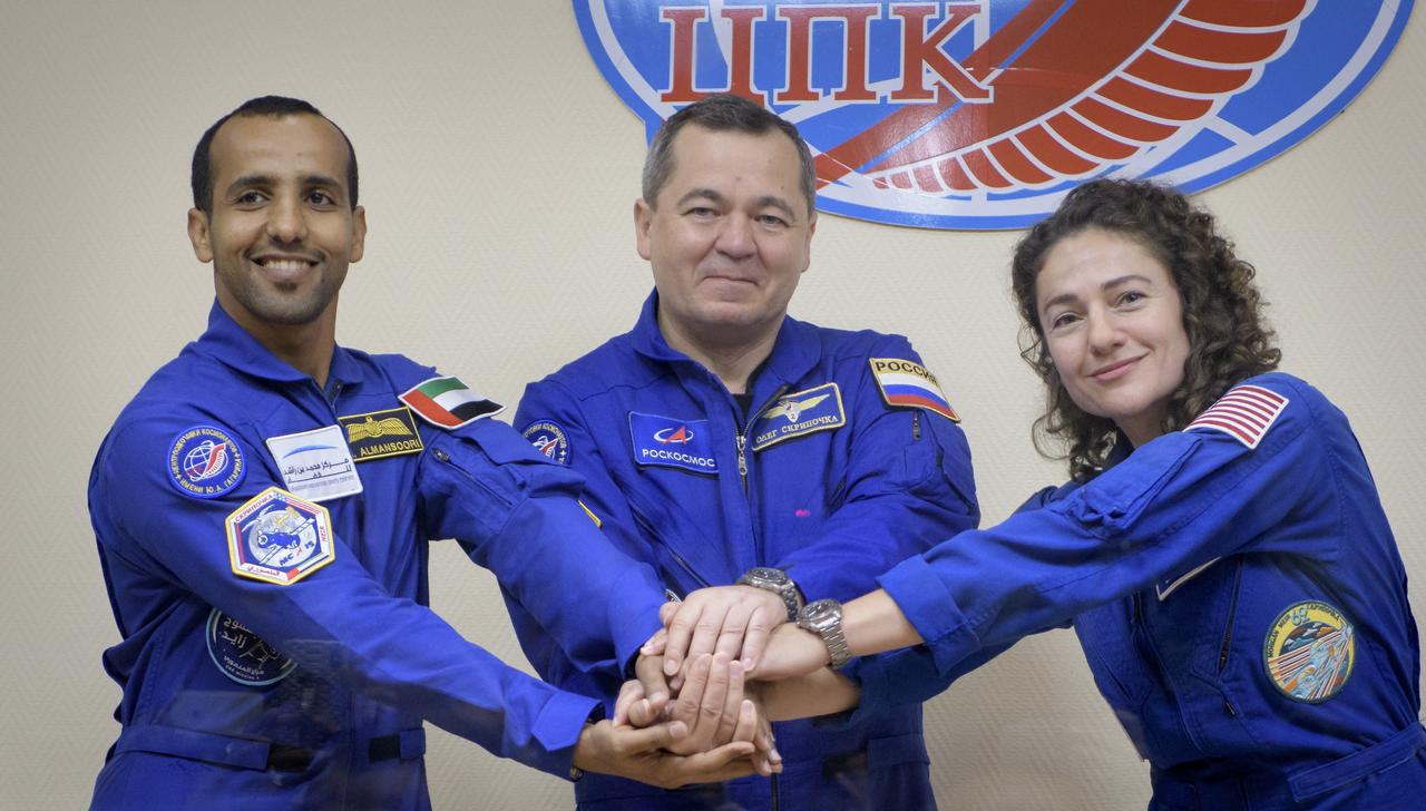Spaceflight participant Hazzaa Ali Almansoori of the United Arab Emirates, left, and Expedition 61 prime crew members Oleg Skripochka of Roscosmos and Jessica Meir of NASA, pose for a photograph at the conclusion of a press conference, Tuesday, Sept. 24, 2019 at the Cosmonaut Hotel in Baikonur, Kazakhstan. Meir, Skripochka, and Almansoori will launch September 25th on the Soyuz MS-15 spacecraft from the Baikonur Cosmodrome to the International Space Station. Photo Credit: (NASA/Bill Ingalls)