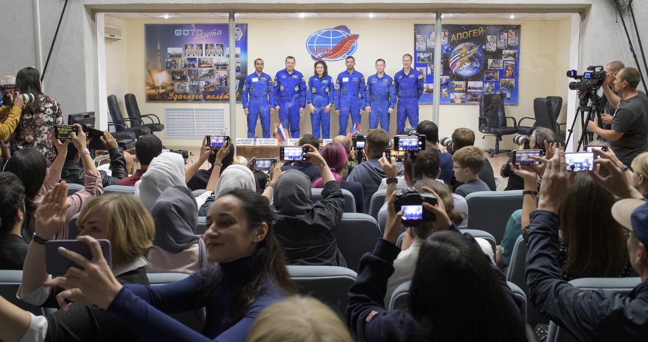 Spaceflight participant Hazzaa Ali Almansoori of the United Arab Emirates, left, Expedition 61 prime crewmembers Oleg Skripochka of Roscosmos and Jessica Meir of NASA, are seen with backup crew members paceflight participant Sultan Al-Neyadi of the United Arab Emirates, Sergei Ryzhikov of Roscosmos and Thomas Marshburn of NASA at the conclusion of a press conference, Tuesday, Sept. 24, 2019 at the Cosmonaut Hotel in Baikonur, Kazakhstan. Meir, Skripochka, and Almansoori will launch September 25th on the Soyuz MS-15 spacecraft from the Baikonur Cosmodrome to the International Space Station. Photo Credit: (NASA/Bill Ingalls)