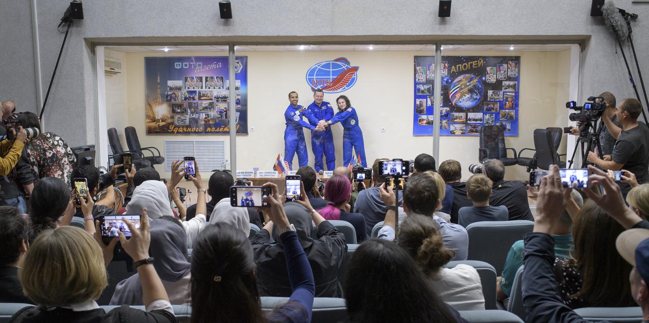 Spaceflight participant Hazzaa Ali Almansoori of the United Arab Emirates, left, and Expedition 61 prime crew members Oleg Skripochka of Roscosmos and Jessica Meir of NASA, pose for a photograph at the conclusion of a press conference, Tuesday, Sept. 24, 2019 at the Cosmonaut Hotel in Baikonur, Kazakhstan. Meir, Skripochka, and Almansoori will launch September 25th on the Soyuz MS-15 spacecraft from the Baikonur Cosmodrome to the International Space Station. Photo Credit: (NASA/Bill Ingalls)