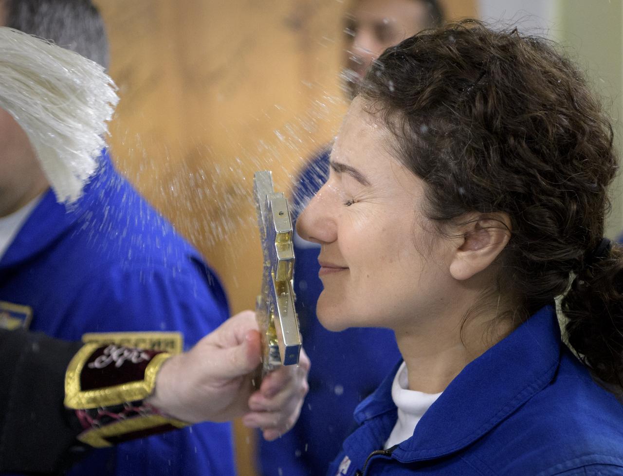 Expedition 61 astronaut Jessica Meir of NASA is blessed by a Russian Orthodox Priest in the Cosmonaut Hotel prior to departing for launch on a Soyuz rocket with Expedition 61 cosmonaut Oleg Skripochka of Roscosmos, and spaceflight participant Hazzaa Ali Almansoori of the United Arab Emirates Wednesday, Sept. 25, 2019 in Baikonur, Kazakhstan. Meir, Skripochka, and Almansoori will launch later in the day on the Soyuz MS-15 spacecraft from the Baikonur Cosmodrome to the International Space Station. Photo Credit: (NASA/Bill Ingalls)