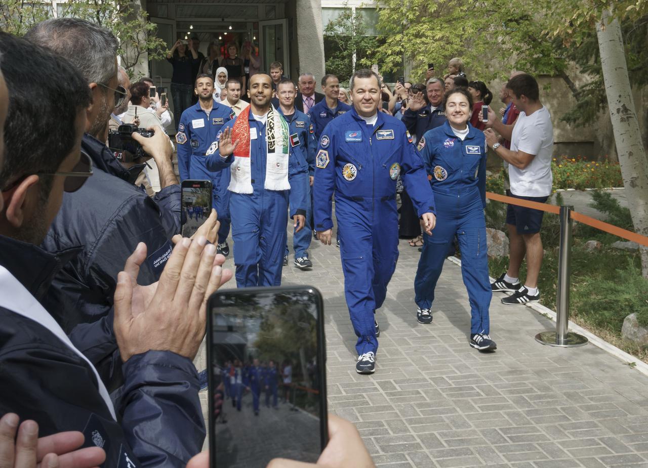 Spaceflight participant Hazzaa Ali Almansoori of the United Arab Emirates, right, Expedition crewmembers Oleg Skripochka of Roscosmos, and Jessica Meir of NASA are seen as they depart the Cosmonaut Hotel ahead of their Soyuz launch to the International Space Station, Wednesday, Sept. 25, 2019 in Baikonur, Kazakhstan. Meir, Skripochka, and Almansoori will launch on the Soyuz MS-15 spacecraft from the Baikonur Cosmodrome to the International Space Station. Photo Credit: (NASA/Victor Zelentsov)