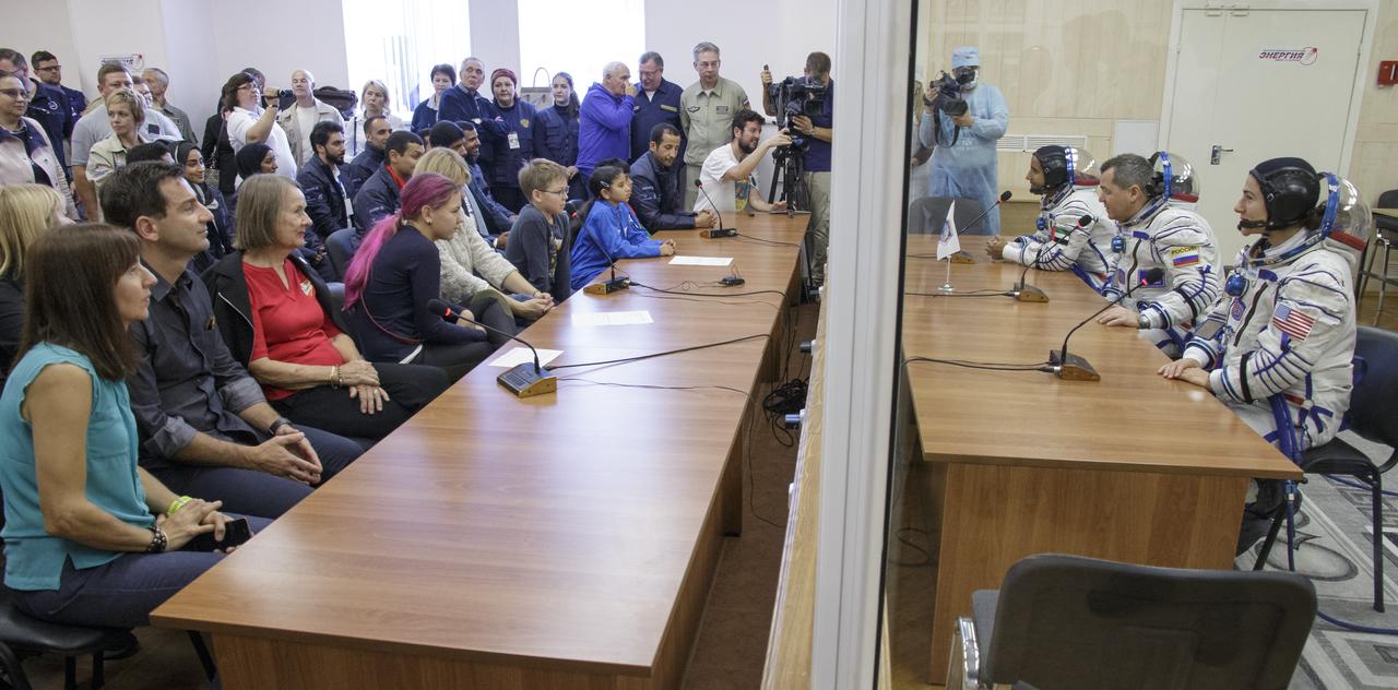 Spaceflight participant Hazzaa Ali Almansoori of the United Arab Emirates, Expedition crewmembers Oleg Skripochka of Roscosmos, and Jessica Meir of NASA talk to friends and family after having their Sokol suits pressure checked a few hours ahead of their launch on a Soyuz rocket, Wednesday, Sept. 25, 2019 at the Baikonur Cosmodrome in Kazakhstan. Meir, Skripochka, and Almansoori will launch on the Soyuz MS-15 spacecraft from the Baikonur Cosmodrome to the International Space Station. Photo Credit: (NASA/Victor Zelentsov)
