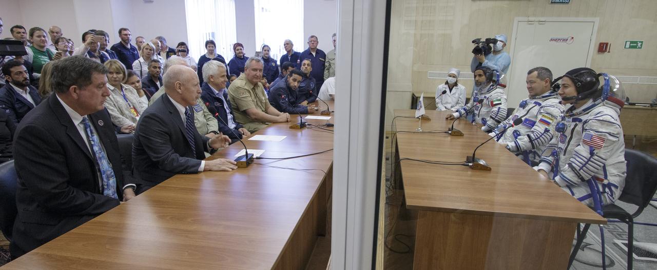 Spaceflight participant Hazzaa Ali Almansoori of the United Arab Emirates, Expedition crewmembers Oleg Skripochka of Roscosmos, and Jessica Meir of NASA talk to officials in charge after having their Sokol suits pressure checked a few hours ahead of their launch on a Soyuz rocket, Wednesday, Sept. 25, 2019 at the Baikonur Cosmodrome in Kazakhstan. Meir, Skripochka, and Almansoori will launch on the Soyuz MS-15 spacecraft from the Baikonur Cosmodrome to the International Space Station. Photo Credit: (NASA/Victor Zelentsov)