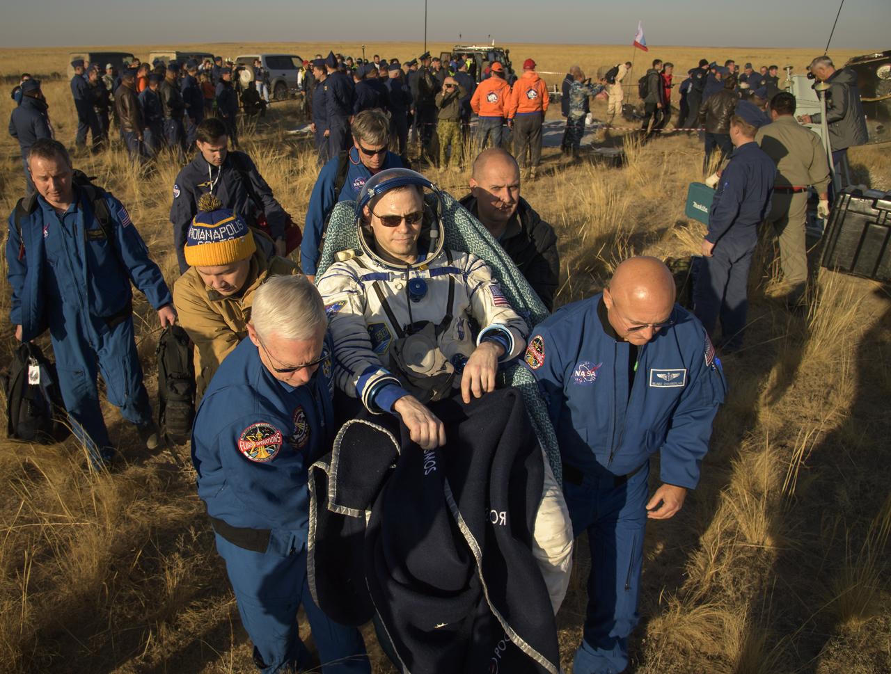 Expedition 60 crewmember Nick Hague of NASA is carried to a medical tent by NASA Chief Astronaut Pat Forrester, left, and NASA Flight Surgeon Blake Chamberlain, right, after he and fellow Expedition 60 crewmember Alexey Ovchinin of Roscosmos and visiting astronaut Hazzaa Ali Almansoori of the United Arab Emirates landed in their Soyuz MS-12 spacecraft near the town of Zhezkazgan, Kazakhstan on Thursday, Oct. 3, 2019. Hague and Ovchinin are returning after 203 days in space where they served as members of the Expedition 59 and 60 crews onboard the International Space Station. Almansoori logged 8 days in space during his first flight as an astronaut. Photo Credit: (NASA/Bill Ingalls)