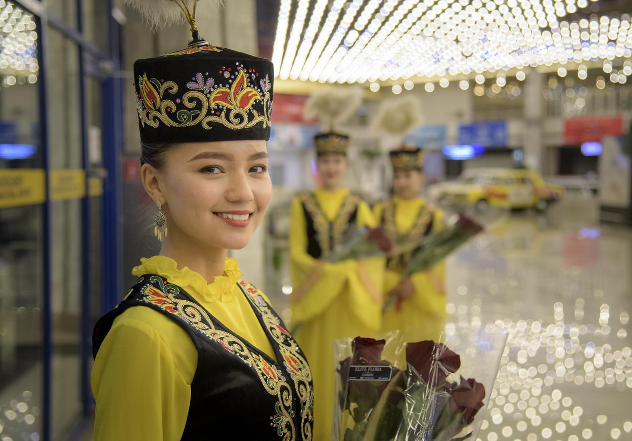 Girls in ceremonial Kazakhstan attire wait to welcome the return of Expedition 60 crew members Nick Hague of NASA and Alexey Ovchinin of Roscosmos, along with visiting astronaut Hazzaa Ali Almansoori of the United Arab Emirates at a Karaganda Airport welcome ceremony in Kazakhstan on Thursday, Oct. 3, 2019. Hague and Ovchinin are returning after 203 days in space where they served as members of the Expedition 59 and 60 crews onboard the International Space Station. Almansoori logged 8 days in space during his first flight as an astronaut. Photo Credit: (NASA/Bill Ingalls)
