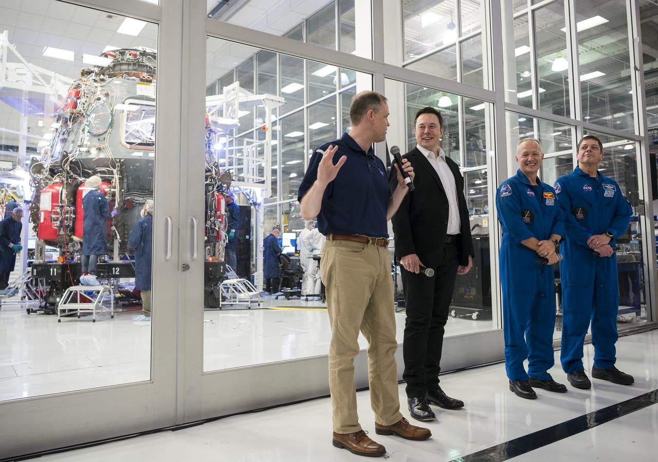 NASA Administrator Jim Bridenstine, left, speaks to press with SpaceX Chief Engineer Elon Musk, second from left, NASA astronaut Doug Hurley, second from right, and NASA astronaut Bob Behnken, in front of the Crew Dragon that is being prepared for the Demo-2 mission, at SpaceX Headquarters, Thursday, Oct. 10, 2019 in Hawthorne, CA. Photo credit: (NASA/Aubrey Gemignani)