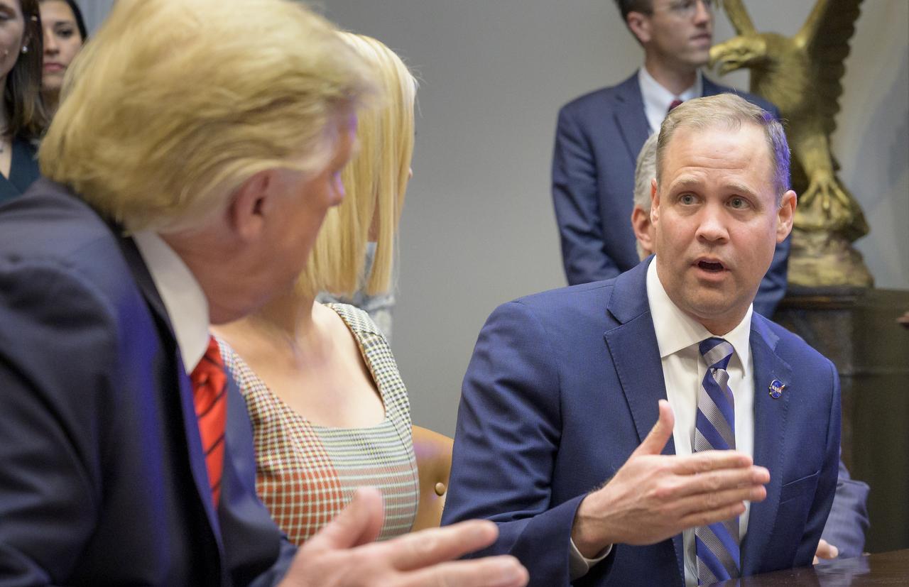 President Donald Trump, left, listens as NASA Administrator Jim Bridenstine talks about the first all-woman spacewalk, Friday, Oct. 18, 2019, from the Roosevelt Room of the White House in Washington. The first all-woman spacewalk in history began at 7:38am EDT with NASA astronauts Christina Koch and Jessica Meir venturing outside the International Space Station to replace a failed battery charge-discharge unit. This is the fourth spacewalk for Koch and Meir’s first. Photo Credit: (NASA/Bill Ingalls)