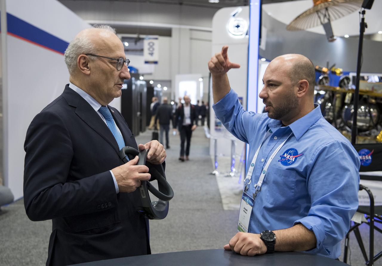 Philippe Étienne, French Ambassador to the U.S. speaks to Joseph Williams about virtual reality viewers at the NASA exhibit during the 70th International Astronautical Congress, Wednesday, Oct. 23, 2019, at the Walter E. Washington Convention Center in Washington. Photo credit: (NASA/Aubrey Gemignani)