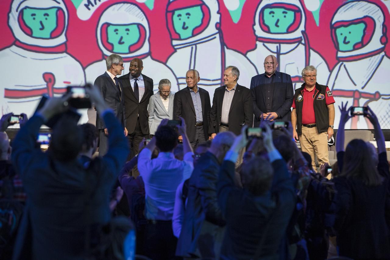 Members of the astronaut panel discussion, from left to right, Roscosmos cosmonaut and executive director for piloted spaceflights, Sergey Krikalev; former NASA astronaut Leland Melvin; former NASA astronaut Mary Cleave; former NASA Administrator and astronaut, Charlie Bolden; former Cosmonaut Dumitru-Dorin Prunariu; ESA (European Space Agency) astronaut, André Kuipers; and European astronaut and professor, Institute of Space Systems, Reinhold Ewald, pose while the audience takes photos, at the conclusion of the event; during the 70th International Astronautical Congress, Friday, Oct. 25, 2019, at the Walter E. Washington Convention Center in Washington. Photo credit: (NASA/Aubrey Gemignani)