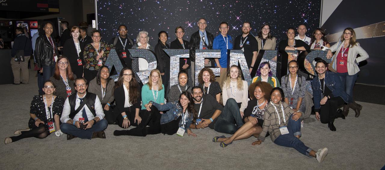 The NASA social group poses for a photo with the Artemis sign during the 70th International Astronautical Congress, Friday, Oct. 25, 2019, at the Walter E. Washington Convention Center in Washington. Photo credit: (NASA/Aubrey Gemignani)