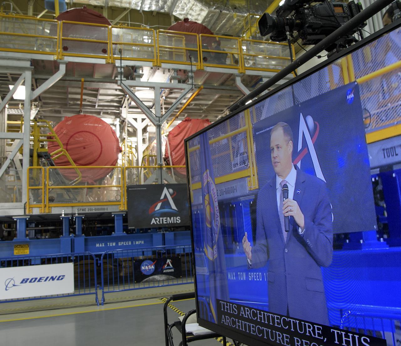 NASA Administrator Jim Bridenstine gives remarks on the agency’s Artemis program, Monday, Dec. 9, 2019, in front of the core stage for NASA’s Space Launch System (SLS) rocket at NASA’s Michoud Assembly Facility in New Orleans. Through Artemis NASA will land the first woman and next man on the Moon by 2024. Photo Credit: (NASA/Bill Ingalls)