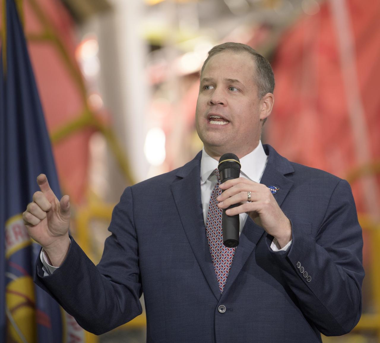 NASA Administrator Jim Bridenstine gives remarks on the agency’s Artemis program, Monday, Dec. 9, 2019, in front of the core stage for NASA’s Space Launch System (SLS) rocket at NASA’s Michoud Assembly Facility in New Orleans. Through Artemis NASA will land the first woman and next man on the Moon by 2024. Photo Credit: (NASA/Bill Ingalls)