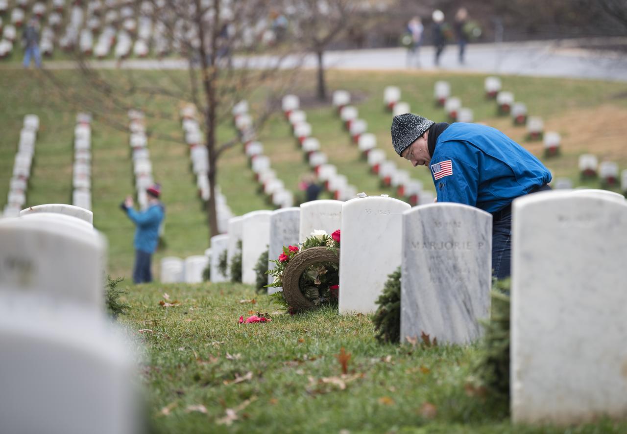 NASA astronaut Doug Wheelock lays a wreath at the gravesite of former astronaut and U.S. Senator John Glenn during National Wreaths Across America Day at Arlington National Cemetery, Sat., Dec. 14, 2019 in Arlington, Va. National Wreaths Across America Day is held annually to celebrate the lives of military veterans and wreaths are placed at the foot of every headstone. Wheelock honored those who lost their lives in the quest for space exploration as well as fellow service members. Photo Credit: (NASA/Aubrey Gemignani)