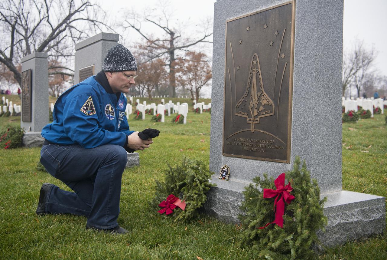 NASA astronaut Doug Wheelock takes a moment after leaving his STS-120 mission patch at the memorial for the Space Shuttle Columbia crew during National Wreaths Across America Day at Arlington National Cemetery, Sat., Dec. 14, 2019 in Arlington, Va. National Wreaths Across America Day is held annually to celebrate the lives of military veterans and wreaths are placed at the foot of every headstone. Wheelock honored those who lost their lives in the quest for space exploration as well as fellow service members. Photo Credit: (NASA/Aubrey Gemignani)