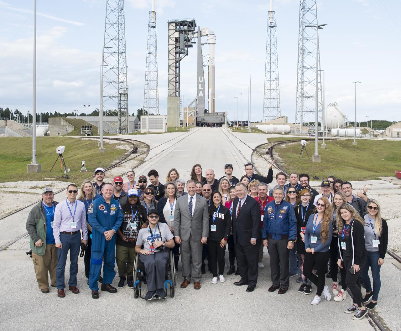 NASA Administrator Jim Bridenstine, NASA Deputy Administrator Jim Morhard, NASA astronaut Barry Wilmore, and Kennedy Space Center Director Bob Cabana, pose for a picture with NASA Social participants in front of a United Launch Alliance Atlas V rocket with Boeing’s CST-100 Starliner spacecraft onboard on the launch pad at Space Launch Complex 41 ahead of the Orbital Flight Test mission, Thursday, Dec. 19, 2019, at Cape Canaveral Air Force Station in Florida. The uncrewed Orbital Flight Test will be Starliner’s maiden mission to the International Space Station for NASA's Commercial Crew Program. The mission, currently targeted for a 6:36 a.m. EST launch on Dec. 20, will serve as an end-to-end test of the system's capabilities. Photo Credit: (NASA/Joel Kowsky)