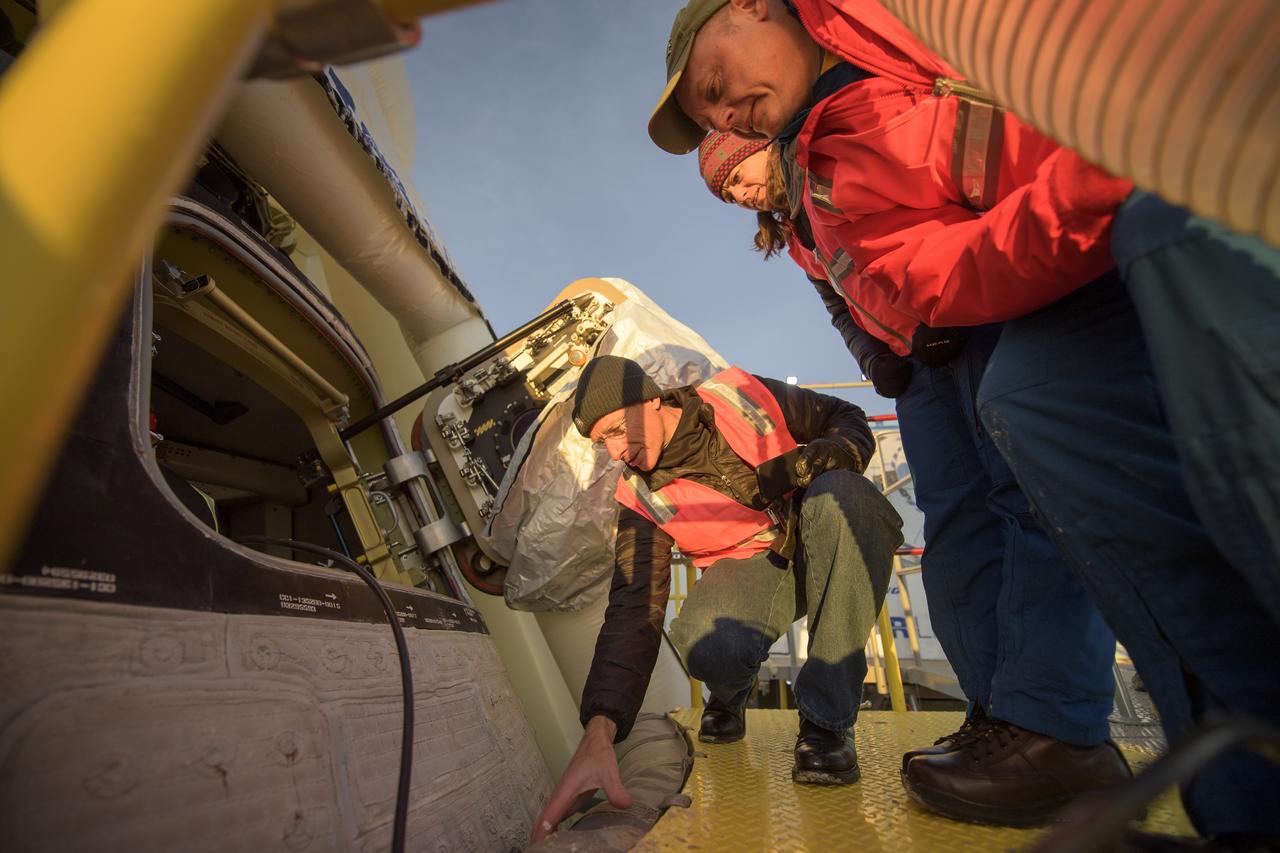 Boeing astronaut Chris Ferguson, left, and NASA astronauts Nicole Mann, and Mike Fincke inspect the Boeing CST-100 Starliner spacecraft shortly after it landed in White Sands, New Mexico, Sunday, Dec. 22, 2019. The landing completes an abbreviated Orbital Flight Test for the company that still meets several mission objectives for NASA’s Commercial Crew program. The Starliner spacecraft launched on a United Launch Alliance Atlas V rocket at 6:36 a.m. Friday, Dec. 20 from Space Launch Complex 41 at Cape Canaveral Air Force Station in Florida. Photo Credit: (NASA/Bill Ingalls)
