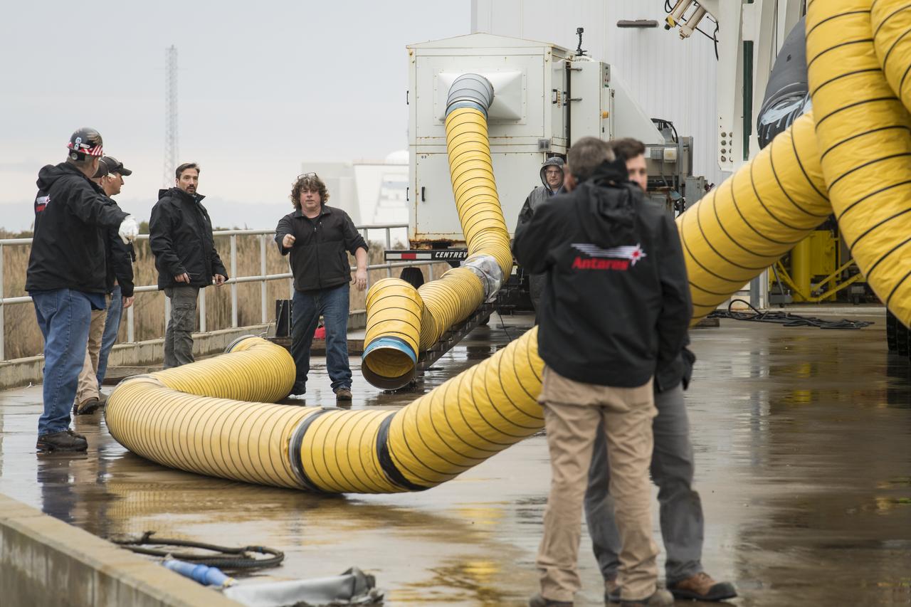 Adjustments are made by rollout crew members as the Northrop Grumman Antares rocket is rolled out to Pad-0A, Wednesday, Feb. 5, 2020, at NASA's Wallops Flight Facility in Virginia. Northrop Grumman’s 13th contracted cargo resupply mission with NASA to the International Space Station will deliver more than 7,500 pounds of science and research, crew supplies and vehicle hardware to the orbital laboratory and its crew. The CRS-13 Cygnus spacecraft is named after the first African American astronaut, Major Robert Henry Lawrence Jr. and is scheduled to launch at 5:39pm EST Sunday, Feb. 9. Photo Credit: (NASA/Aubrey Gemignani)