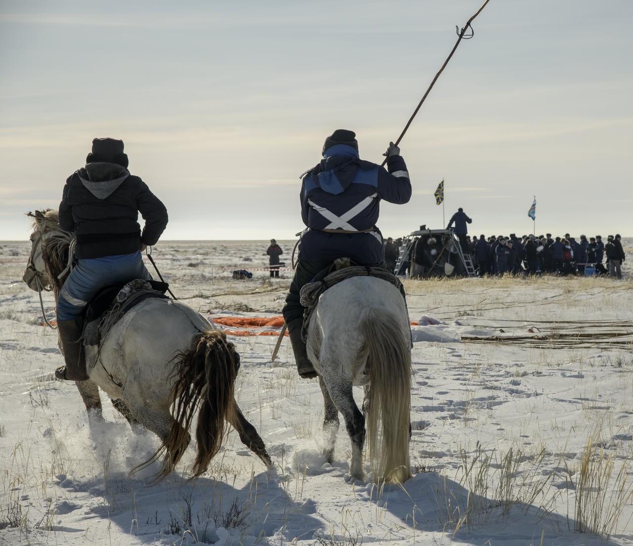 Two locals on horseback arrive at the Soyuz MS-13 spacecraft shortly after it landed in a remote area near the town of Zhezkazgan, Kazakhstan with Expedition 61 crew members Christina Koch of NASA, Alexander Skvortsov of the Russian space agency Roscosmos, and Luca Parmitano of ESA (European Space Agency) Thursday, Feb. 6, 2020. Koch returned to Earth after logging 328 days in space --- the longest spaceflight in history by a woman --- as a member of Expeditions 59-60-61 on the International Space Station. Skvortsov and Parmitano returned after 201 days in space where they served as Expedition 60-61 crew members onboard the station. Photo Credit: (NASA/Bill Ingalls)