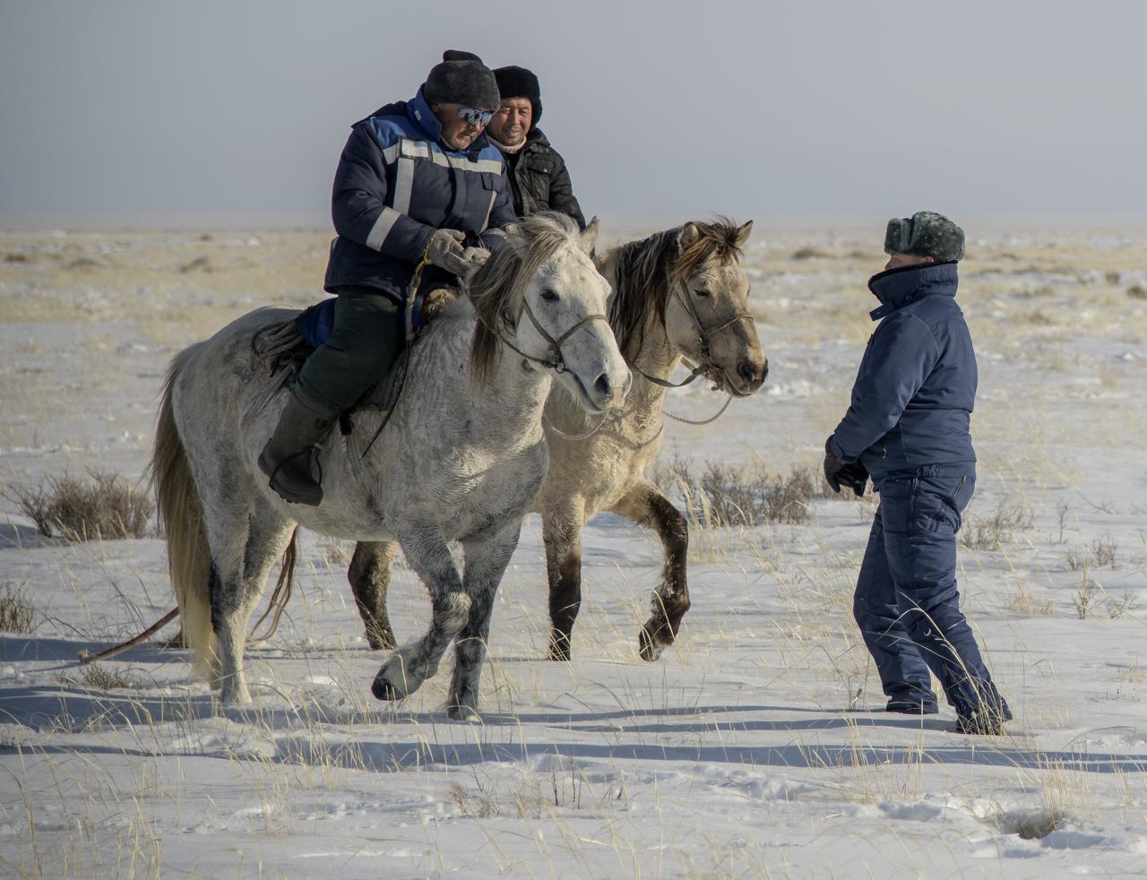 Two locals on horseback arrive at the Soyuz MS-13 spacecraft shortly after it landed in a remote area near the town of Zhezkazgan, Kazakhstan with Expedition 61 crew members Christina Koch of NASA, Alexander Skvortsov of the Russian space agency Roscosmos, and Luca Parmitano of ESA (European Space Agency) Thursday, Feb. 6, 2020. Koch returned to Earth after logging 328 days in space --- the longest spaceflight in history by a woman --- as a member of Expeditions 59-60-61 on the International Space Station. Skvortsov and Parmitano returned after 201 days in space where they served as Expedition 60-61 crew members onboard the station. Photo Credit: (NASA/Bill Ingalls)