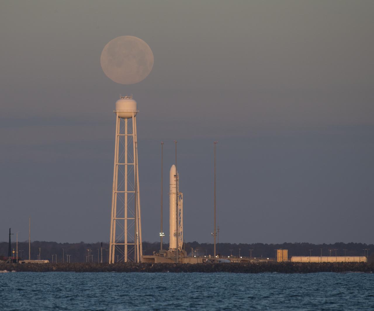 A Northrop Grumman Antares rocket carrying a Cygnus resupply spacecraft is seen at sunrise as the Moon sets on Pad-0A, Sunday, Feb. 9, 2020, at NASA's Wallops Flight Facility in Virginia. Northrop Grumman’s 13th contracted cargo resupply mission with NASA to the International Space Station will deliver more than 7,500 pounds of science and research, crew supplies and vehicle hardware to the orbital laboratory and its crew. The CRS-13 Cygnus spacecraft is named after the first African American astronaut, Major Robert Henry Lawrence Jr.. Photo Credit: (NASA/Aubrey Gemignani)