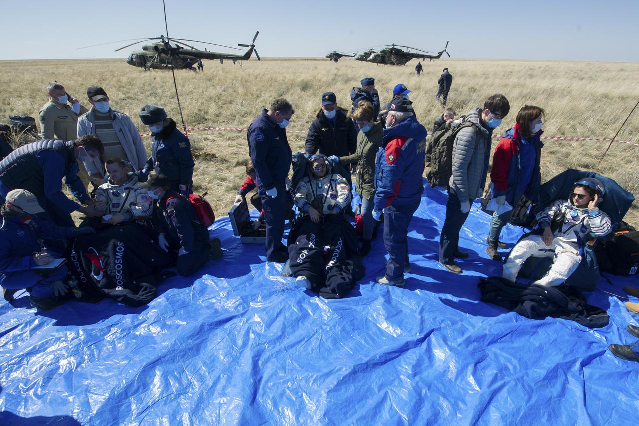 Expedition 62 crew members Andrew Morgan of NASA, left, Oleg Skripochka of Roscosmos, center, and Jessica Meir of NASA sit in chairs outside the Soyuz MS-15 spacecraft after they landed in a remote area near the town of Zhezkazgan, Kazakhstan on Friday, April 17, 2020. Meir and Skripochka returned after 205 days in space, and Morgan after 272 days in space. All three served as Expedition 60-61-62 crew members onboard the International Space Station. Photo Credit: (NASA/GCTC/Andrey Shelepin)