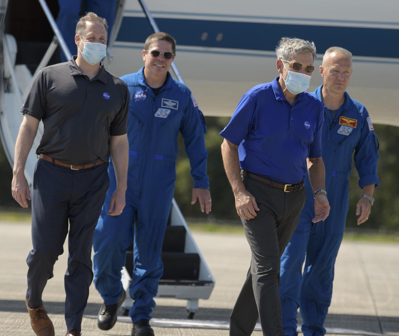 NASA Administrator Jim Bridenstine, foreground left, and Kennedy Space Center Director Bob Cabana, foreground right, greet NASA astronauts Robert Behnken, background left, and Douglas Hurley as they arrive at the Launch and Landing Facility at NASA’s Kennedy Space Center ahead of SpaceX’s Demo-2 mission, Wednesday, May 20, 2020, in Florida. NASA’s SpaceX Demo-2 mission is the first launch with astronauts of the SpaceX Crew Dragon spacecraft and Falcon 9 rocket to the International Space Station as part of the agency’s Commercial Crew Program. The flight test will serve as an end-to-end demonstration of SpaceX’s crew transportation system. Behnken and Hurley are scheduled to launch at 4:33 p.m. EDT on Wednesday, May 27, from Launch Complex 39A at the Kennedy Space Center. A new era of human spaceflight is set to begin as American astronauts once again launch on an American rocket from American soil to low-Earth orbit for the first time since the conclusion of the Space Shuttle Program in 2011.  Photo Credit: (NASA/Bill Ingalls)