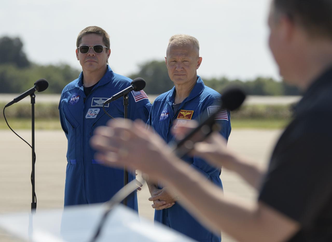 NASA astronauts Robert Behnken, left, and Douglas Hurley listen as NASA Administrator Jim Bridenstine gives remarks after the crew arrived at the Launch and Landing Facility at NASA’s Kennedy Space Center ahead of SpaceX’s Demo-2 mission, Wednesday, May 20, 2020, in Florida. NASA’s SpaceX Demo-2 mission is the first launch with astronauts of the SpaceX Crew Dragon spacecraft and Falcon 9 rocket to the International Space Station as part of the agency’s Commercial Crew Program. The flight test will serve as an end-to-end demonstration of SpaceX’s crew transportation system. Behnken and Hurley are scheduled to launch at 4:33 p.m. EDT on Wednesday, May 27, from Launch Complex 39A at the Kennedy Space Center. A new era of human spaceflight is set to begin as American astronauts once again launch on an American rocket from American soil to low-Earth orbit for the first time since the conclusion of the Space Shuttle Program in 2011. Photo Credit: (NASA/Bill Ingalls)