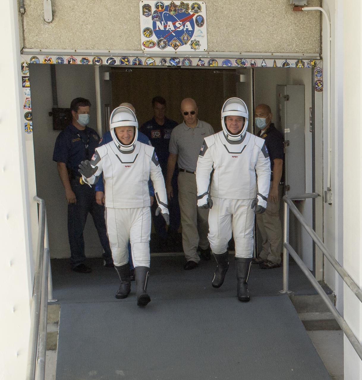 NASA astronauts Douglas Hurley, left, and Robert Behnken, wearing SpaceX spacesuits, are seen as they depart the Neil A. Armstrong Operations and Checkout Building for Launch Complex 39A during a dress rehearsal prior to the Demo-2 mission launch, Saturday, May 23, 2020, at NASA’s Kennedy Space Center in Florida. NASA’s SpaceX Demo-2 mission is the first launch with astronauts of the SpaceX Crew Dragon spacecraft and Falcon 9 rocket to the International Space Station as part of the agency’s Commercial Crew Program. The test flight serves as an end-to-end demonstration of SpaceX’s crew transportation system. Behnken and Hurley are scheduled to launch at 4:33 p.m. EDT on Wednesday, May 27, from Launch Complex 39A at the Kennedy Space Center. A new era of human spaceflight is set to begin as American astronauts once again launch on an American rocket from American soil to low-Earth orbit for the first time since the conclusion of the Space Shuttle Program in 2011.  Photo Credit: (NASA/Bill Ingalls)