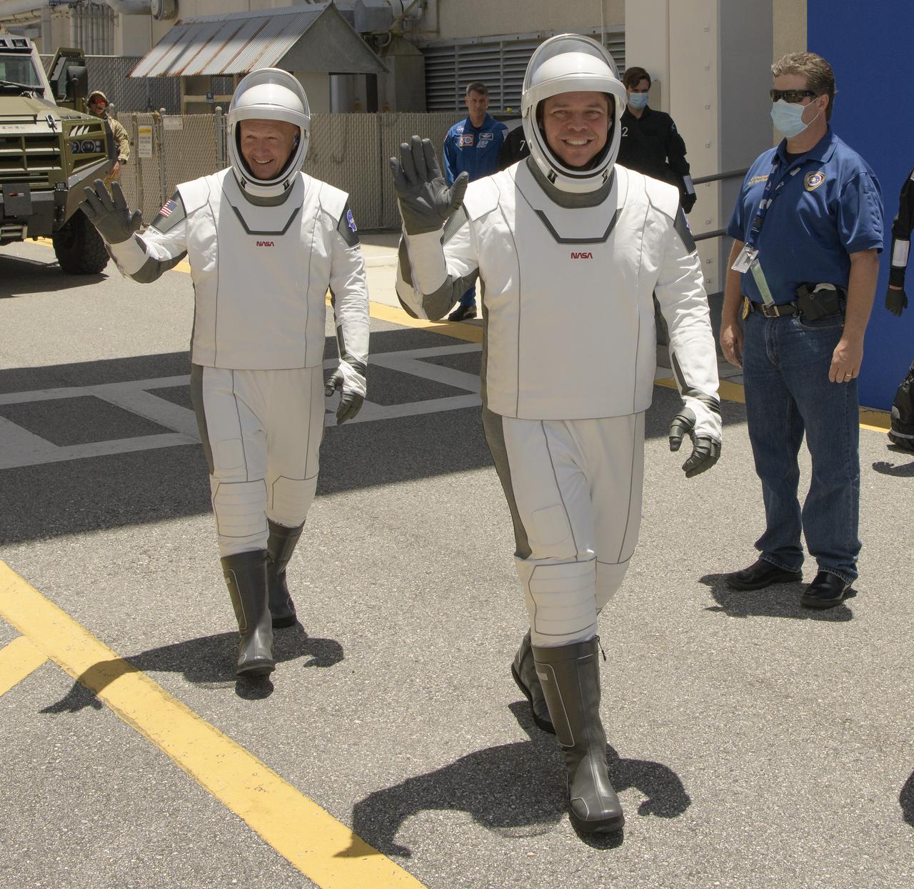NASA astronauts Douglas Hurley, left, and Robert Behnken, wearing SpaceX spacesuits, are seen as they depart the Neil A. Armstrong Operations and Checkout Building for Launch Complex 39A during a dress rehearsal prior to the Demo-2 mission launch, Saturday, May 23, 2020, at NASA’s Kennedy Space Center in Florida. NASA’s SpaceX Demo-2 mission is the first launch with astronauts of the SpaceX Crew Dragon spacecraft and Falcon 9 rocket to the International Space Station as part of the agency’s Commercial Crew Program. The test flight serves as an end-to-end demonstration of SpaceX’s crew transportation system. Behnken and Hurley are scheduled to launch at 4:33 p.m. EDT on Wednesday, May 27, from Launch Complex 39A at the Kennedy Space Center. A new era of human spaceflight is set to begin as American astronauts once again launch on an American rocket from American soil to low-Earth orbit for the first time since the conclusion of the Space Shuttle Program in 2011.  Photo Credit: (NASA/Bill Ingalls)