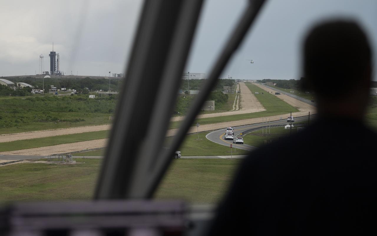 The convoy carrying NASA astronauts Robert Behnken and Douglas Hurley is seen through the windows of firing room four as it makes its way to Launch Complex 39A ahead of the launch of NASA’s SpaceX Demo-2 mission, Wednesday, May 27, 2020, in firing room four of the Launch Control Center at NASA’s Kennedy Space Center in Florida. NASA’s SpaceX Demo-2 mission is the first launch with astronauts of the SpaceX Crew Dragon spacecraft and Falcon 9 rocket to the International Space Station as part of the agency’s Commercial Crew Program. The test flight serves as an end-to-end demonstration of SpaceX’s crew transportation system. Behnken and Hurley are scheduled to launch at 4:33 p.m. EDT on Wednesday, May 27, from Launch Complex 39A at the Kennedy Space Center. A new era of human spaceflight is set to begin as American astronauts once again launch on an American rocket from American soil to low-Earth orbit for the first time since the conclusion of the Space Shuttle Program in 2011. Photo Credit: (NASA/Joel Kowsky)