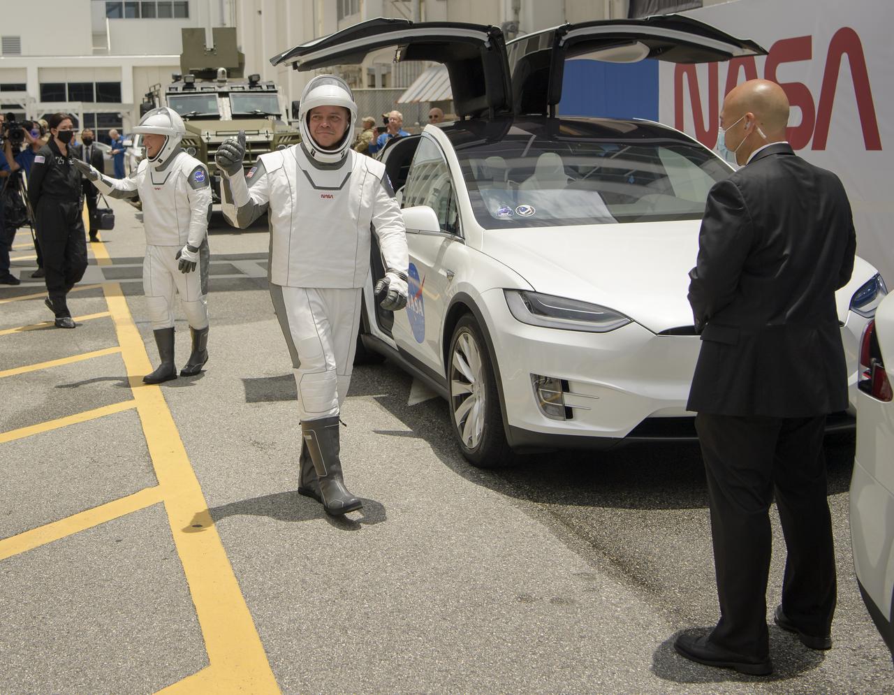 NASA astronauts Douglas Hurley, left, and Robert Behnken, wearing SpaceX spacesuits, are seen as they prepare to depart the Neil A. Armstrong Operations and Checkout Building for Launch Complex 39A to board the SpaceX Crew Dragon spacecraft for the Demo-2 mission launch, Wednesday, May 27, 2020, at NASA’s Kennedy Space Center in Florida. NASA’s SpaceX Demo-2 mission is the first launch with astronauts of the SpaceX Crew Dragon spacecraft and Falcon 9 rocket to the International Space Station as part of the agency’s Commercial Crew Program. The test flight serves as an end-to-end demonstration of SpaceX’s crew transportation system. Behnken and Hurley are scheduled to launch at 4:33 p.m. EDT on Wednesday, May 27, from Launch Complex 39A at the Kennedy Space Center. A new era of human spaceflight is set to begin as American astronauts once again launch on an American rocket from American soil to low-Earth orbit for the first time since the conclusion of the Space Shuttle Program in 2011. Photo Credit: (NASA/Bill Ingalls)