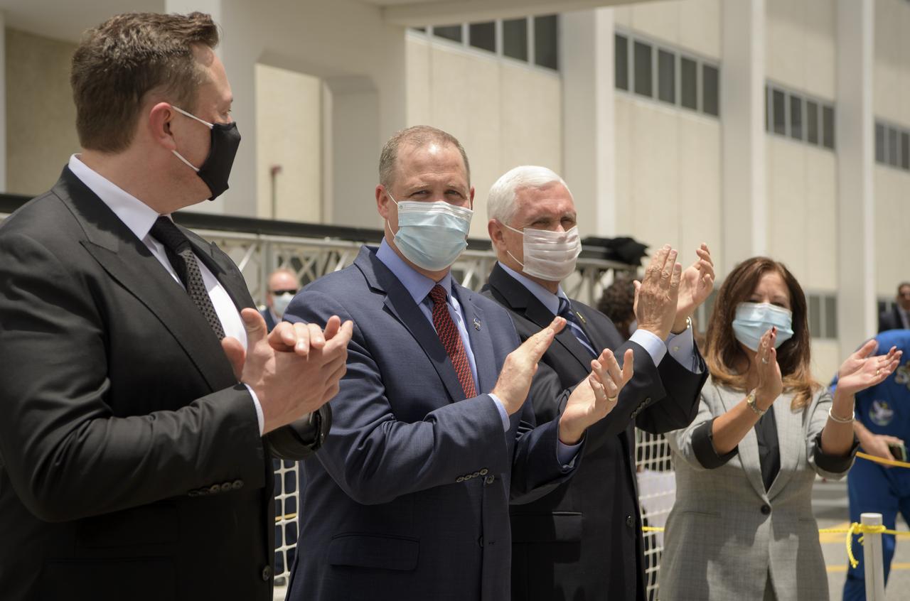 Elon Musk, SpaceX Chief Engineer, left,  NASA Administrator Jim Bridenstine, Vice President Mike Pence, and Second Lady Karen Pence, are seen as NASA astronauts Douglas Hurley and Robert Behnken depart the Neil A. Armstrong Operations and Checkout Building for Launch Complex 39A to board the SpaceX Crew Dragon spacecraft for the Demo-2 mission launch, Wednesday, May 27, 2020, at NASA’s Kennedy Space Center in Florida. NASA’s SpaceX Demo-2 mission is the first launch with astronauts of the SpaceX Crew Dragon spacecraft and Falcon 9 rocket to the International Space Station as part of the agency’s Commercial Crew Program. The test flight serves as an end-to-end demonstration of SpaceX’s crew transportation system. Behnken and Hurley are scheduled to launch at 4:33 p.m. EDT on Wednesday, May 27, from Launch Complex 39A at the Kennedy Space Center. A new era of human spaceflight is set to begin as American astronauts once again launch on an American rocket from American soil to low-Earth orbit for the first time since the conclusion of the Space Shuttle Program in 2011.  Photo Credit: (NASA/Bill Ingalls)
