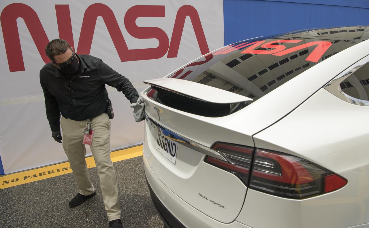 The driver of the vehicle prepared to take NASA astronauts Douglas Hurley and Robert Behnken from the Neil A. Armstrong Operations and Checkout Building for Launch Complex 39A to board the SpaceX Crew Dragon spacecraft for the Demo-2 mission launch, takes a moment to wipe off water from a passing rain shower, Wednesday, May 27, 2020, at NASA’s Kennedy Space Center in Florida. NASA’s SpaceX Demo-2 mission is the first launch with astronauts of the SpaceX Crew Dragon spacecraft and Falcon 9 rocket to the International Space Station as part of the agency’s Commercial Crew Program. The test flight serves as an end-to-end demonstration of SpaceX’s crew transportation system. Today’s launch of Behnken and Hurley was scrubbed due to weather and is now scheduled for 3:22 p.m. EDT on Saturday, May 30, from Launch Complex 39A at the Kennedy Space Center. A new era of human spaceflight is set to begin as American astronauts once again launch on an American rocket from American soil to low-Earth orbit for the first time since the conclusion of the Space Shuttle Program in 2011.  Photo Credit: (NASA/Bill Ingalls)